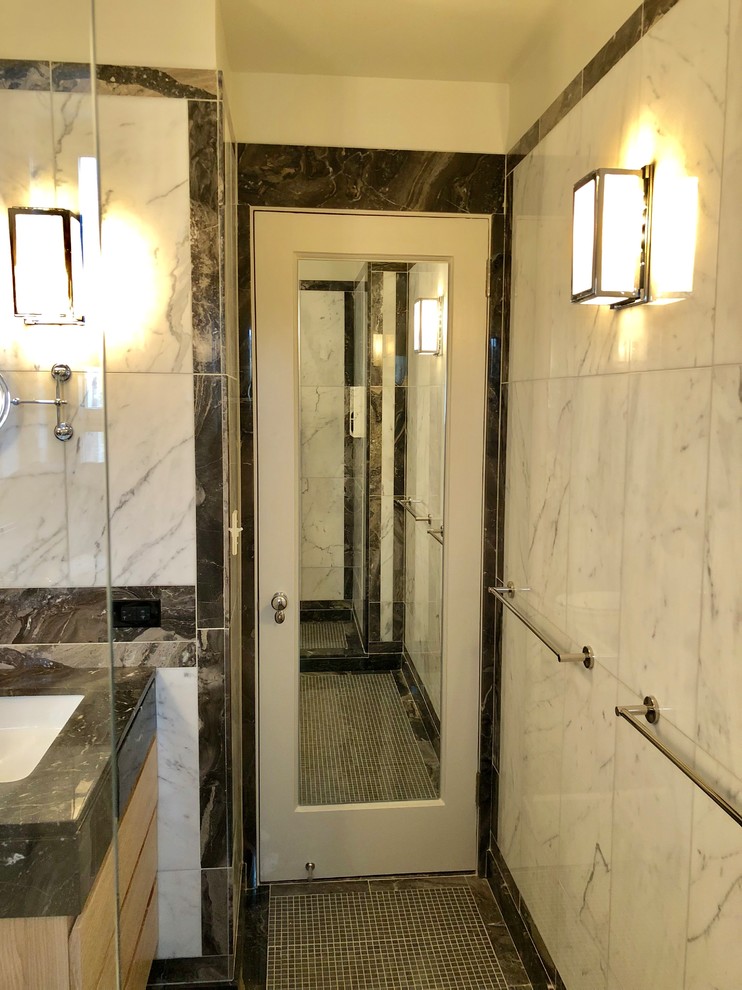 Bathroom - mid-sized contemporary white tile and marble tile mosaic tile floor and black floor bathroom idea in New York with flat-panel cabinets, light wood cabinets, a two-piece toilet, white walls, an undermount sink, marble countertops and black countertops