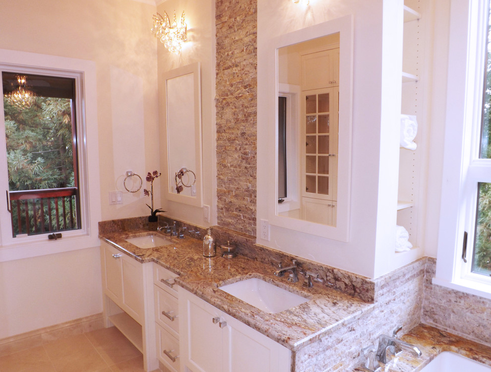 Inredning av ett klassiskt stort en-suite badrum, med släta luckor, vita skåp, ett undermonterat badkar, en toalettstol med separat cisternkåpa, beige kakel, stenkakel, beige väggar, marmorgolv, ett undermonterad handfat och marmorbänkskiva