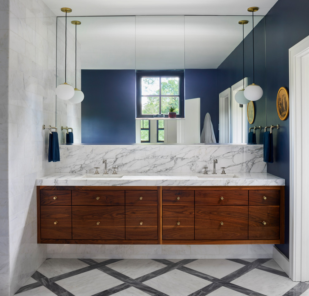 На фото: большая главная ванная комната в скандинавском стиле с плоскими фасадами, фасадами цвета дерева среднего тона, отдельно стоящей ванной, двойным душем, раздельным унитазом, белой плиткой, мраморной плиткой, синими стенами, мраморным полом, врезной раковиной, мраморной столешницей, разноцветным полом, душем с распашными дверями, белой столешницей, нишей, тумбой под две раковины и подвесной тумбой
