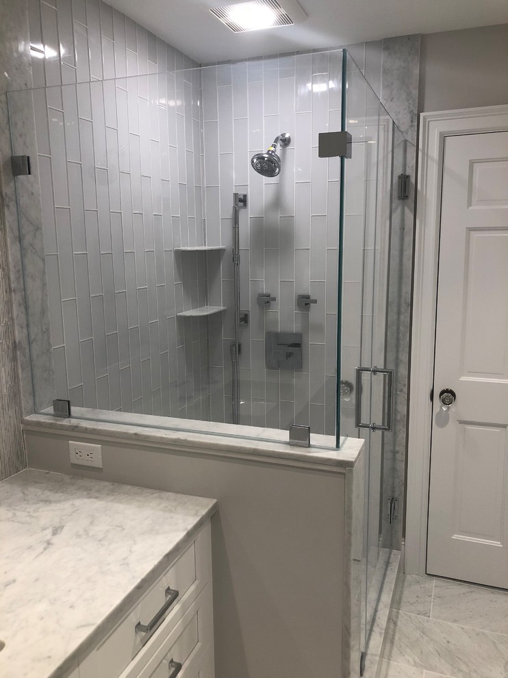 Ejemplo de cuarto de baño clásico renovado con ducha esquinera, baldosas y/o azulejos grises, baldosas y/o azulejos de vidrio, suelo de mármol, encimera de mármol, suelo gris, ducha con puerta con bisagras y encimeras blancas