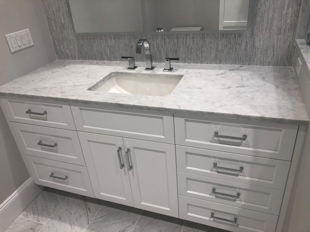 Classic bathroom in New York with a corner shower, grey tiles, glass tiles, marble flooring, marble worktops, grey floors, a hinged door and white worktops.