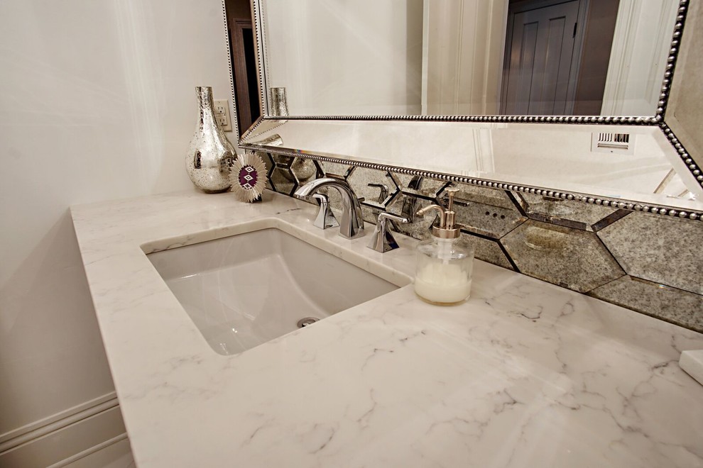Small mirror tile bathroom photo in New Orleans with white walls, an undermount sink and marble countertops