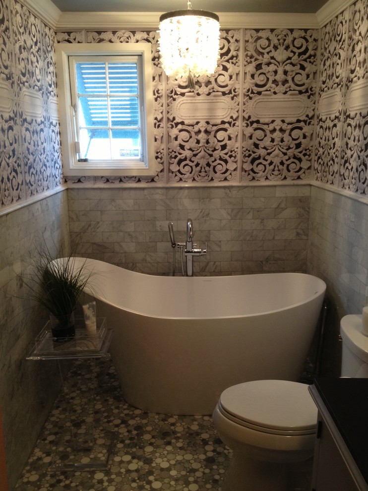 Foto di una stanza da bagno minimal con vasca freestanding, piastrelle in pietra e top in granito