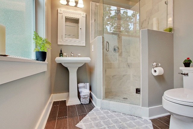 Kleines Klassisches Badezimmer mit Sockelwaschbecken, Eckdusche, Toilette mit Aufsatzspülkasten, grauer Wandfarbe und Porzellan-Bodenfliesen in New Orleans