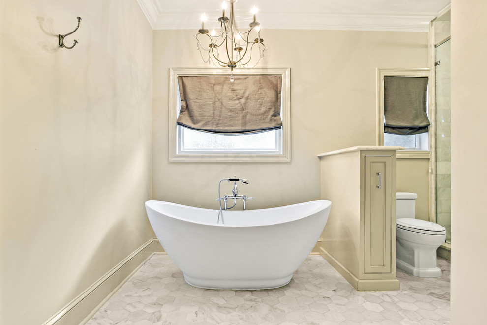 Freestanding bathtub - mid-sized transitional master gray tile, white tile and marble tile marble floor and white floor freestanding bathtub idea in New Orleans with a one-piece toilet, beige walls and a hinged shower door