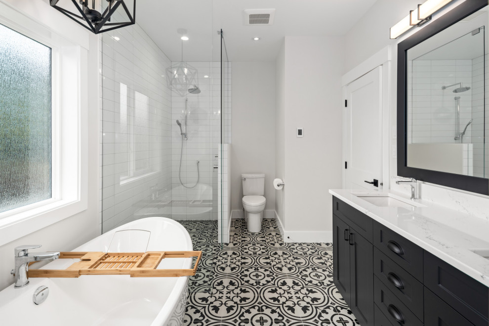 Inspiration for a mid-sized transitional master white tile and subway tile porcelain tile, black floor and double-sink bathroom remodel in Vancouver with shaker cabinets, black cabinets, a one-piece toilet, gray walls, a drop-in sink, quartz countertops, white countertops and a built-in vanity