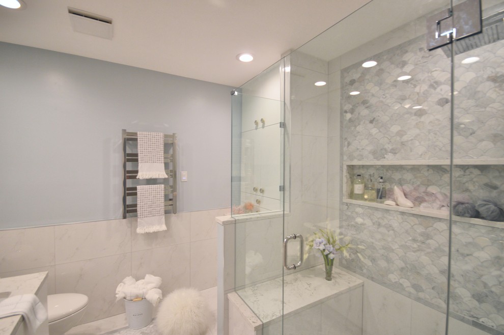 Immagine di una stanza da bagno con WC monopezzo, pavimento in marmo, lavabo sottopiano e porta doccia a battente