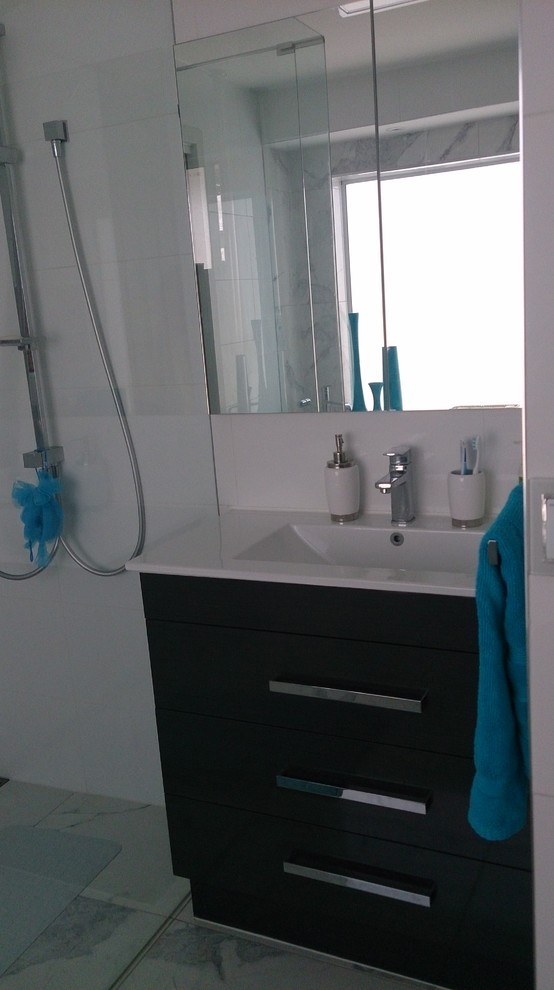 Example of a mid-sized minimalist white tile and porcelain tile porcelain tile freestanding bathtub design in Melbourne with an integrated sink, flat-panel cabinets, dark wood cabinets, solid surface countertops, a two-piece toilet and white walls