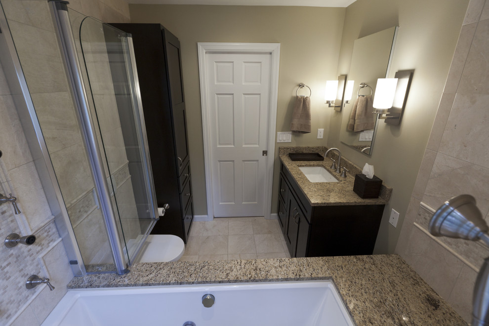 Inspiration for a small timeless beige tile and stone tile marble floor tub/shower combo remodel in Bridgeport with an undermount sink, shaker cabinets, dark wood cabinets, granite countertops, an undermount tub, a wall-mount toilet and beige walls