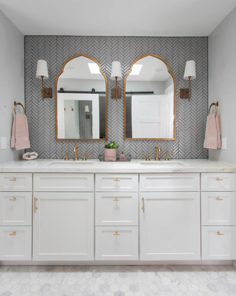 This is an example of a medium sized traditional ensuite bathroom in Denver with recessed-panel cabinets, white cabinets, an alcove shower, a one-piece toilet, grey tiles, glass tiles, grey walls, marble flooring, a submerged sink, marble worktops, white floors, a hinged door and white worktops.