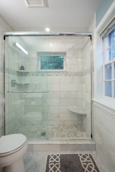 Photo of a small classic ensuite bathroom in DC Metro with a submerged sink, glass-front cabinets, dark wood cabinets, marble worktops, an alcove bath, an alcove shower, a one-piece toilet, white tiles, stone tiles, white walls and marble flooring.