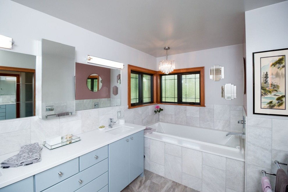 Photo of a medium sized midcentury ensuite bathroom in Detroit with freestanding cabinets, blue cabinets, a built-in bath, a submerged sink and solid surface worktops.