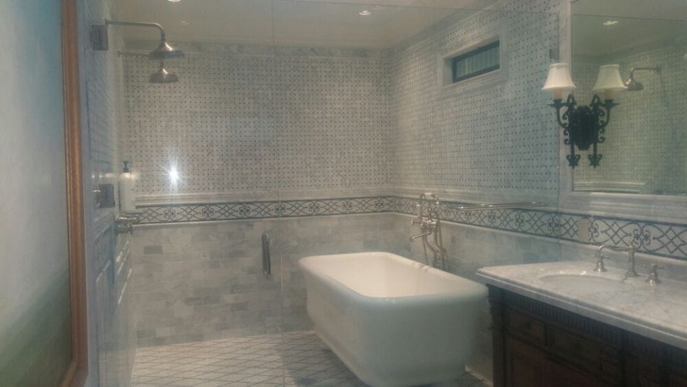 Bild på ett mellanstort vintage en-suite badrum, med luckor med upphöjd panel, skåp i mörkt trä, ett fristående badkar, en dusch i en alkov, grå kakel, kakelplattor, grå väggar, kalkstensgolv, ett undermonterad handfat, marmorbänkskiva, grått golv och dusch med gångjärnsdörr