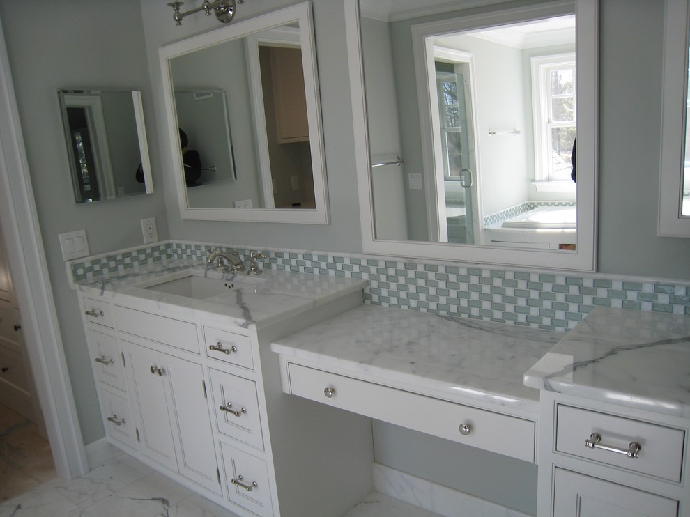 Idée de décoration pour une grande salle de bain principale tradition avec un placard à porte affleurante, des portes de placard blanches, une baignoire d'angle, un carrelage multicolore, un mur gris, un sol en marbre, un lavabo encastré, un plan de toilette en marbre et un sol blanc.