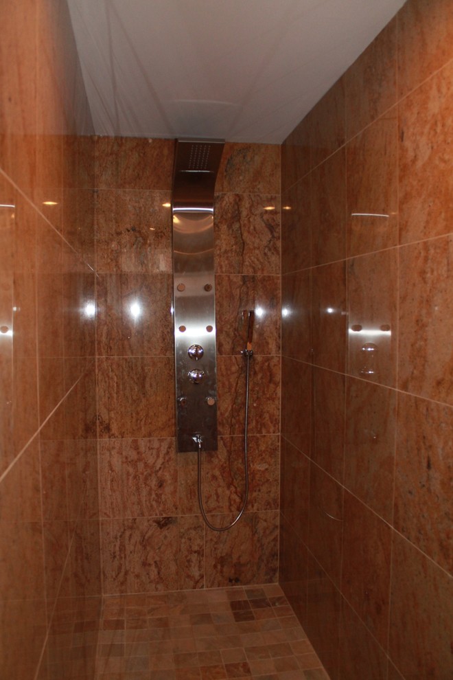 Esempio di una stanza da bagno con doccia mediterranea di medie dimensioni con consolle stile comò, ante in legno scuro, doccia alcova, piastrelle beige, piastrelle in pietra, pareti beige, pavimento in marmo e top in granito