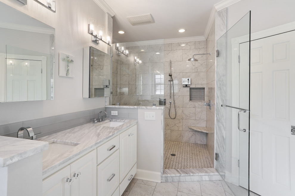 Photo of a medium sized classic ensuite bathroom in New Orleans with raised-panel cabinets, white cabinets, a freestanding bath, a shower/bath combination, a two-piece toilet, white tiles, marble tiles, grey walls, marble flooring, a submerged sink, marble worktops, white floors, a hinged door, white worktops, a wall niche, double sinks and a built in vanity unit.