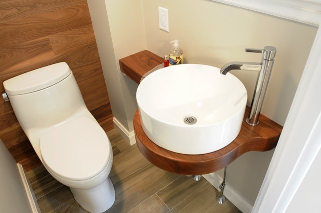Cette image montre une petite salle de bain design en bois foncé avec une vasque, un placard sans porte, un plan de toilette en bois, WC à poser, un carrelage vert, un mur multicolore et un sol en carrelage de porcelaine.