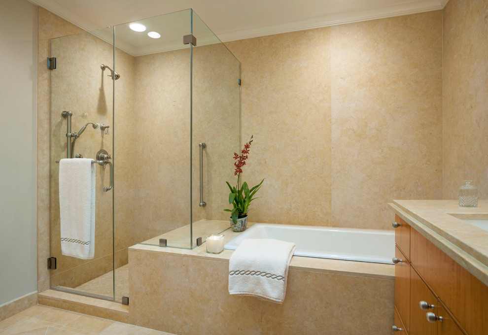 Foto de cuarto de baño principal contemporáneo con lavabo bajoencimera, armarios con paneles lisos, puertas de armario de madera clara, encimera de mármol, bañera encastrada y suelo de mármol