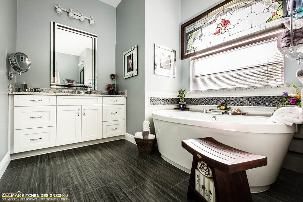 Freestanding bathtub - mid-sized contemporary master gray tile and porcelain tile porcelain tile freestanding bathtub idea in Orlando with an undermount sink, shaker cabinets, white cabinets, granite countertops and gray walls