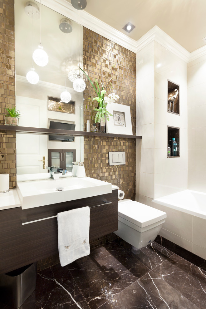 Modernes Badezimmer mit Aufsatzwaschbecken, flächenbündigen Schrankfronten, dunklen Holzschränken, Badewanne in Nische, Wandtoilette, weißen Fliesen und weißer Waschtischplatte in Montreal