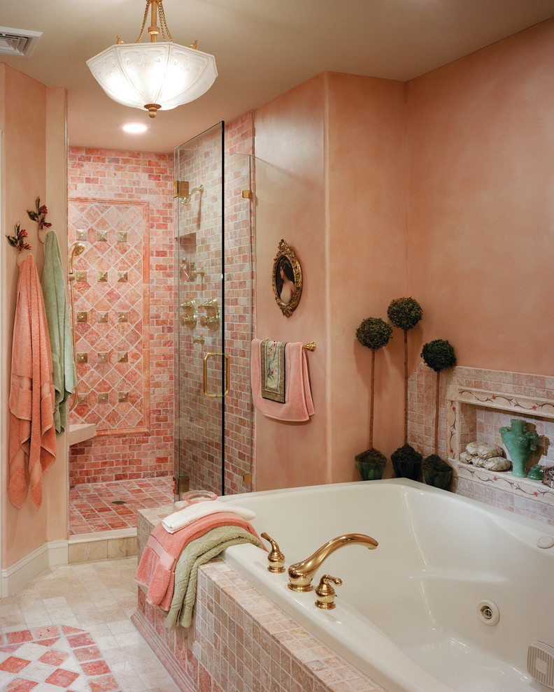 This is an example of a mediterranean ensuite bathroom in Philadelphia with a one-piece toilet, orange tiles, pink tiles, orange walls, marble flooring, a submerged sink, marble worktops, beige floors, a hinged door, a built-in bath and an alcove shower.