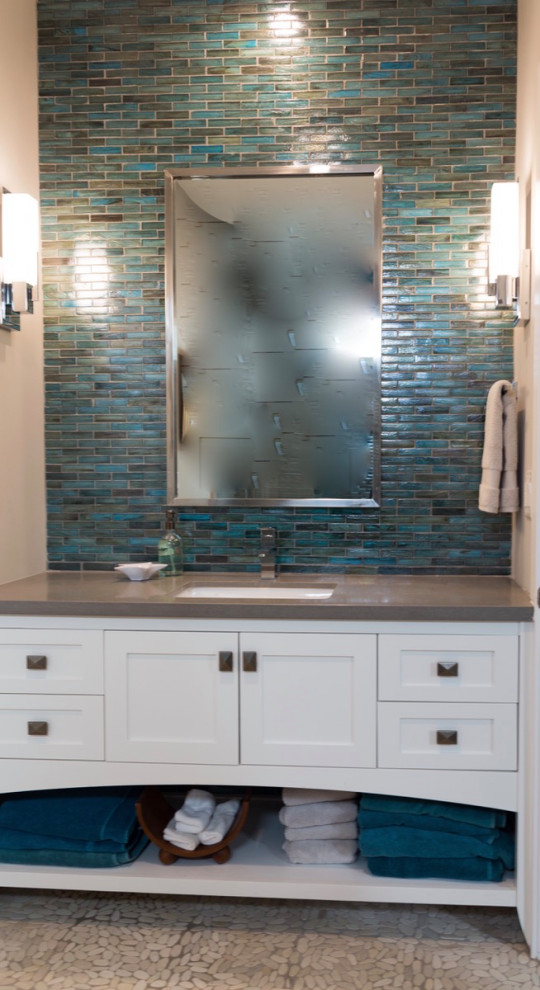Bathroom - mid-sized coastal 3/4 blue tile and glass tile pebble tile floor, beige floor and single-sink bathroom idea in Orange County with shaker cabinets, white cabinets, a two-piece toilet, white walls, an undermount sink, solid surface countertops, a hinged shower door, gray countertops and a built-in vanity