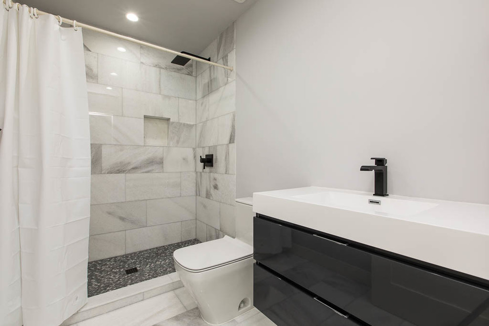 Foto di una piccola stanza da bagno con doccia contemporanea con ante lisce, ante nere, doccia alcova, WC monopezzo, pareti grigie, lavabo integrato, pavimento grigio, doccia con tenda e top bianco