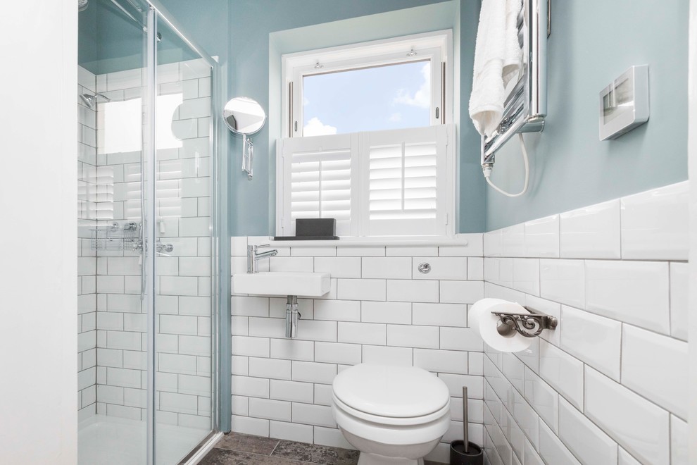 Mid-sized beach style 3/4 blue tile and subway tile cement tile floor and multicolored floor bathroom photo in Kent with a wall-mount toilet, blue walls and a wall-mount sink