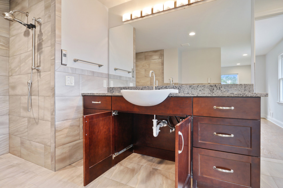 Inredning av ett modernt stort grå grått en-suite badrum, med skåp i shakerstil, bruna skåp, en kantlös dusch, en toalettstol med separat cisternkåpa, grå kakel, keramikplattor, vita väggar, cementgolv, ett integrerad handfat, granitbänkskiva, grått golv och med dusch som är öppen