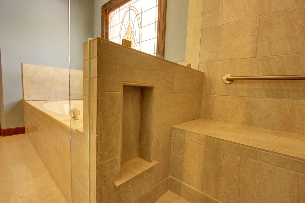 Cette image montre une salle de bain principale traditionnelle de taille moyenne avec une baignoire posée, une douche à l'italienne, un carrelage beige, un carrelage de pierre, un mur gris et un sol en travertin.