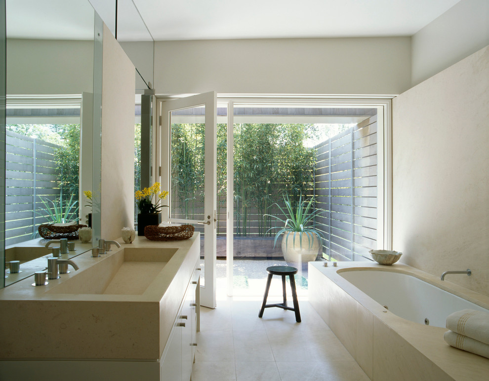 Idées déco pour une salle de bain contemporaine avec un lavabo intégré, une baignoire encastrée et un carrelage beige.