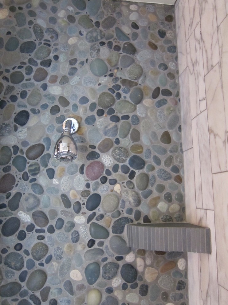 Cette image montre une petite salle de bain principale bohème avec un placard à porte plane, des portes de placard grises, un plan de toilette en calcaire, un carrelage gris, une douche d'angle, WC à poser et un carrelage de pierre.