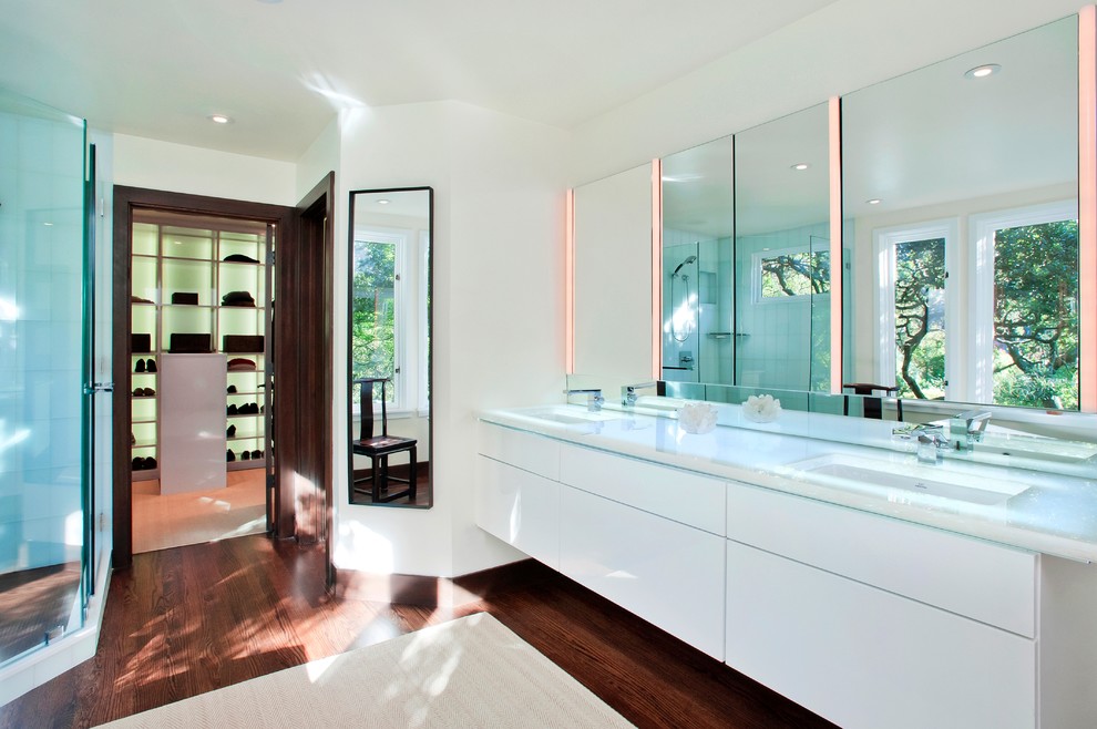 Inspiration pour une salle de bain design avec un plan de toilette en verre et un lavabo encastré.