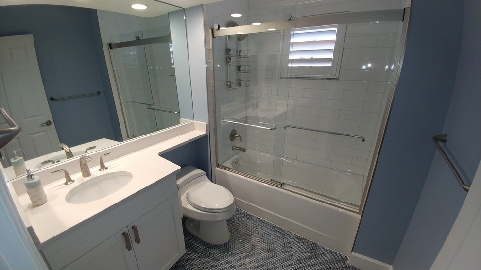Medium sized traditional bathroom in Tampa with shaker cabinets, white cabinets, an alcove bath, an alcove shower, a two-piece toilet, white tiles, porcelain tiles, blue walls, ceramic flooring, a submerged sink and engineered stone worktops.