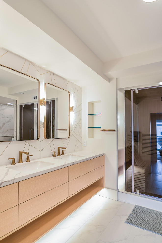 Пример оригинального дизайна: главная ванная комната среднего размера в современном стиле с плоскими фасадами, светлыми деревянными фасадами, японской ванной, душевой комнатой, унитазом-моноблоком, белой плиткой, мраморной плиткой, белыми стенами, полом из керамогранита, врезной раковиной, столешницей из искусственного кварца, белым полом, душем с распашными дверями, белой столешницей, тумбой под две раковины и подвесной тумбой