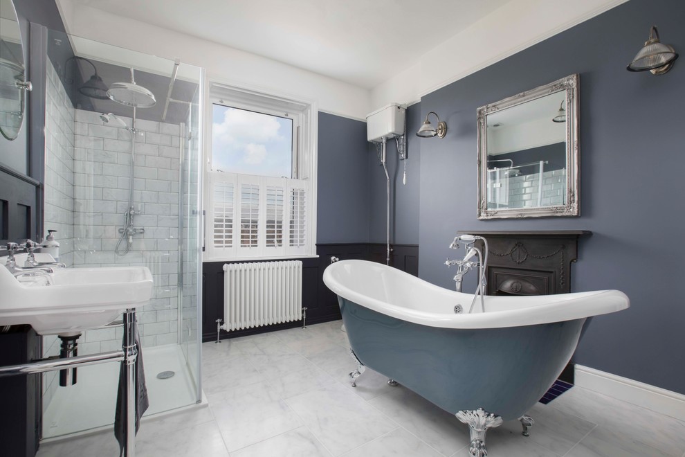 Пример оригинального дизайна: большая детская ванная комната в морском стиле с ванной на ножках, угловым душем, белой плиткой, плиткой кабанчик, синими стенами, консольной раковиной, серым полом и душем с распашными дверями