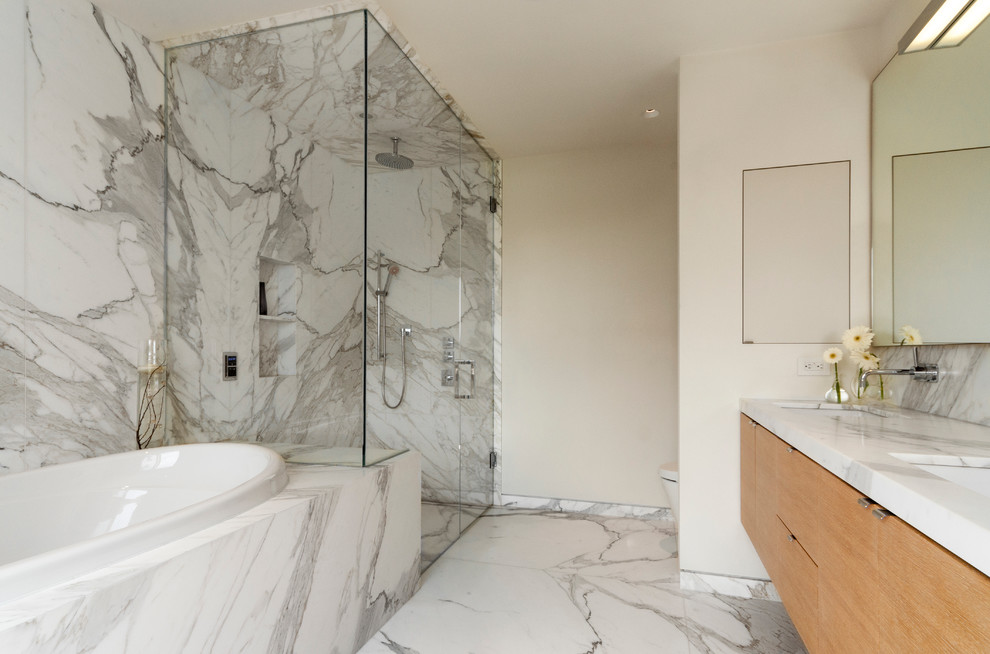 This is an example of a medium sized scandinavian ensuite bathroom in Toronto with a submerged sink, flat-panel cabinets, light wood cabinets, marble worktops, a built-in bath, a built-in shower, a one-piece toilet, white tiles, stone slabs, white walls and marble flooring.