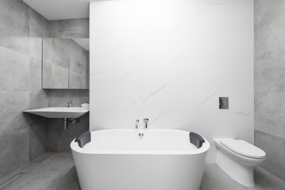 Idée de décoration pour une salle de bain nordique avec une baignoire indépendante, une douche ouverte, WC suspendus, un carrelage blanc, du carrelage en marbre et un lavabo suspendu.