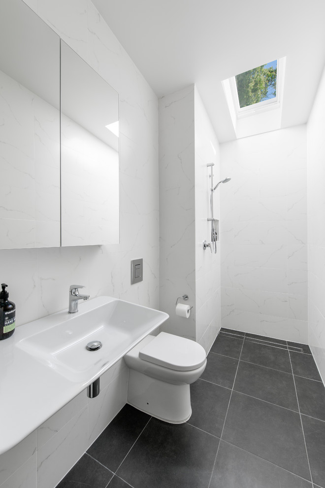 Cette photo montre une salle de bain tendance avec une baignoire indépendante, une douche ouverte, WC suspendus, un carrelage blanc, du carrelage en marbre et un lavabo suspendu.
