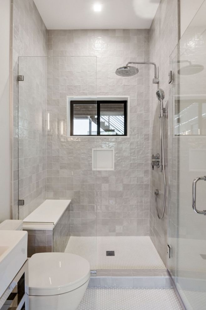 Пример оригинального дизайна: ванная комната среднего размера в современном стиле с открытыми фасадами, серыми фасадами, душем в нише, раздельным унитазом, серой плиткой, керамической плиткой, белыми стенами, полом из керамогранита, монолитной раковиной, столешницей из искусственного кварца, белым полом, душем с распашными дверями, белой столешницей, сиденьем для душа, тумбой под одну раковину и напольной тумбой