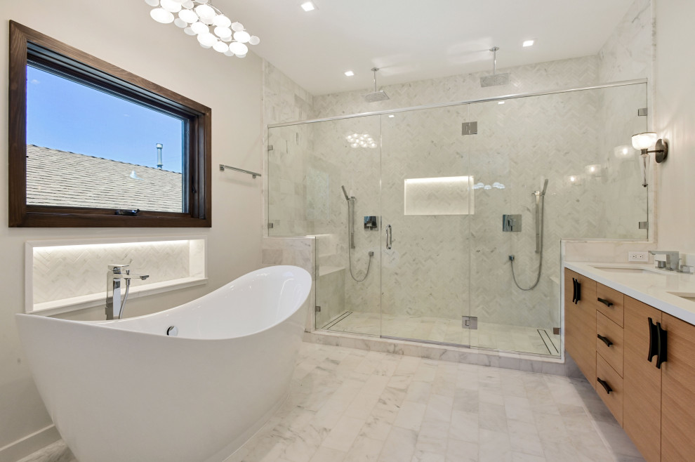 Modern inredning av ett stort vit vitt en-suite badrum, med släta luckor, skåp i ljust trä, ett fristående badkar, en dubbeldusch, en toalettstol med separat cisternkåpa, vit kakel, stenkakel, vita väggar, ett undermonterad handfat, bänkskiva i kvarts, vitt golv och dusch med gångjärnsdörr