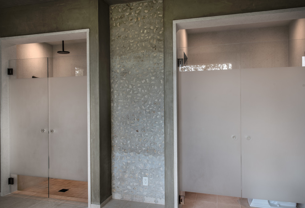 Modelo de cuarto de baño mediterráneo con lavabo bajoencimera, armarios con paneles lisos, puertas de armario de madera en tonos medios, bañera exenta y paredes grises