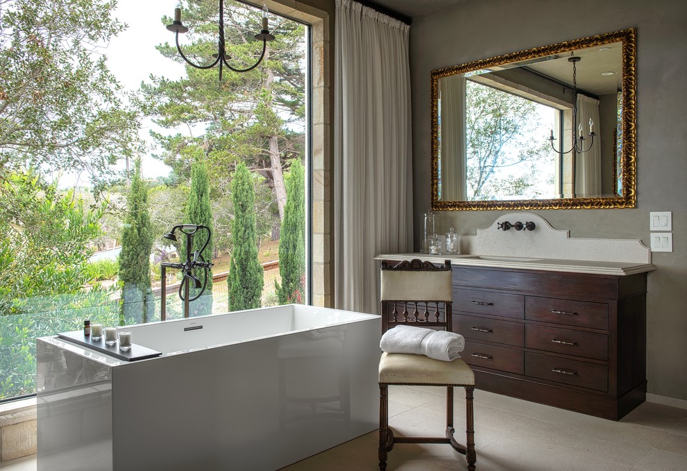 サンフランシスコにある地中海スタイルのおしゃれな浴室 (アンダーカウンター洗面器、フラットパネル扉のキャビネット、濃色木目調キャビネット、置き型浴槽、グレーの壁) の写真