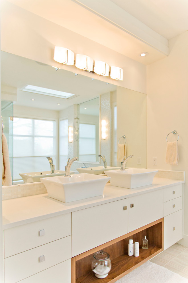 Modelo de cuarto de baño tradicional renovado con lavabo sobreencimera, armarios con paneles lisos, puertas de armario blancas y paredes blancas