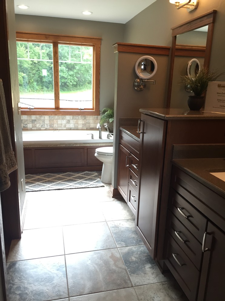 Example of a large arts and crafts master multicolored tile and ceramic tile ceramic tile bathroom design in Other with shaker cabinets, brown cabinets, a two-piece toilet, green walls, an integrated sink and solid surface countertops