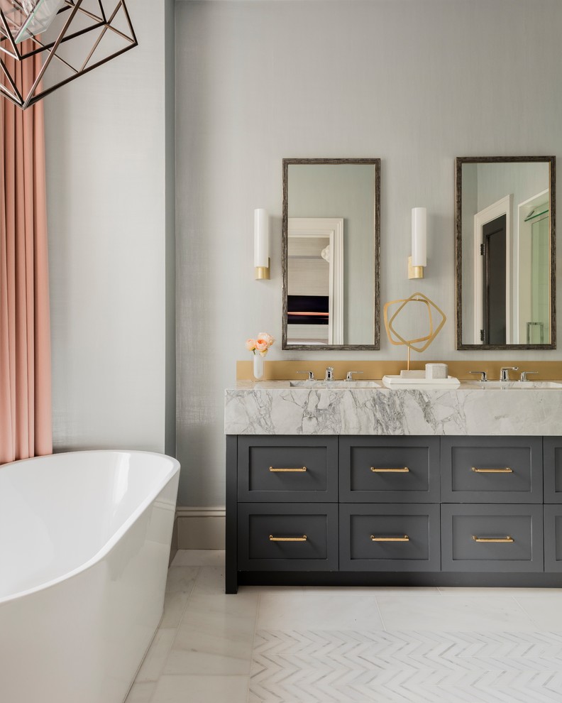 Design ideas for a large classic ensuite bathroom in Boston with recessed-panel cabinets, grey cabinets, a freestanding bath, an alcove shower, a one-piece toilet, grey walls, marble flooring, a submerged sink, marble worktops, white floors, a hinged door and white worktops.