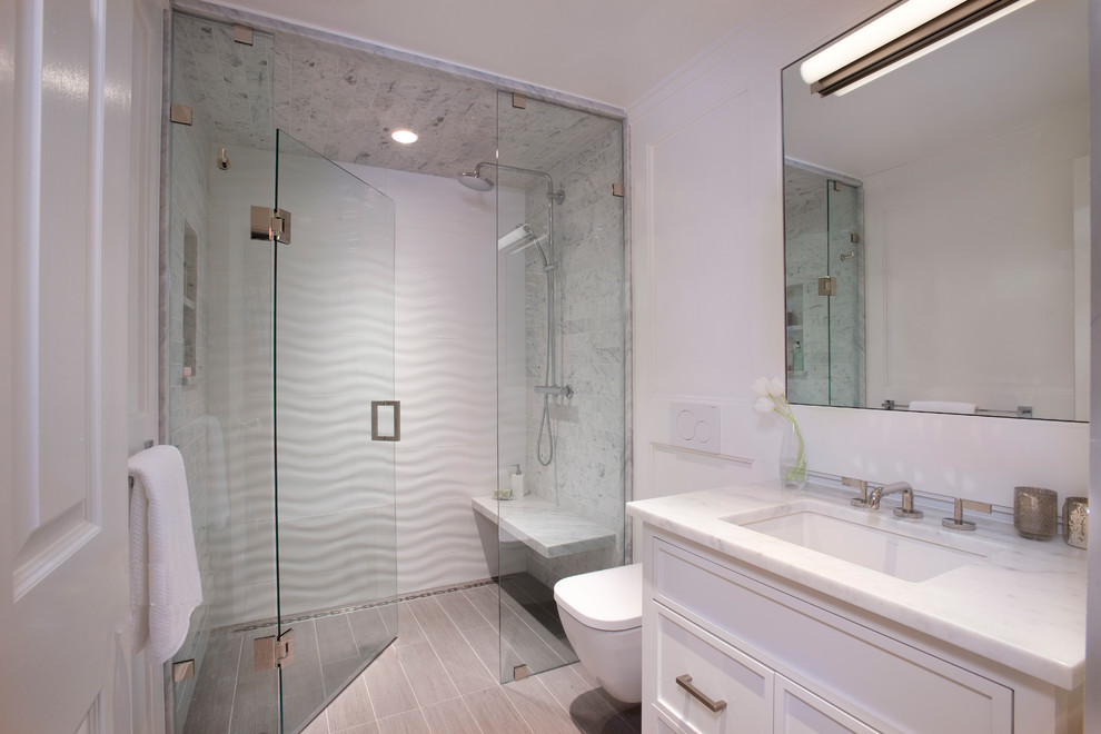 Inspiration for a mid-sized transitional 3/4 gray tile, white tile and marble tile vinyl floor walk-in shower remodel in Boston with shaker cabinets, white cabinets, a wall-mount toilet, white walls, an undermount sink and marble countertops
