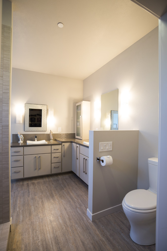 Idéer för ett mellanstort modernt grå en-suite badrum, med släta luckor, vita skåp, ett badkar i en alkov, en dusch/badkar-kombination, en toalettstol med hel cisternkåpa, grå kakel, porslinskakel, grå väggar, klinkergolv i porslin, ett fristående handfat, bänkskiva i kvarts, brunt golv och dusch med duschdraperi