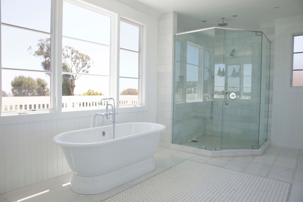 Exempel på ett stort maritimt en-suite badrum, med ett undermonterad handfat, skåp i shakerstil, vita skåp, marmorbänkskiva, ett fristående badkar, en hörndusch, en toalettstol med hel cisternkåpa, vit kakel, stenkakel, vita väggar och marmorgolv