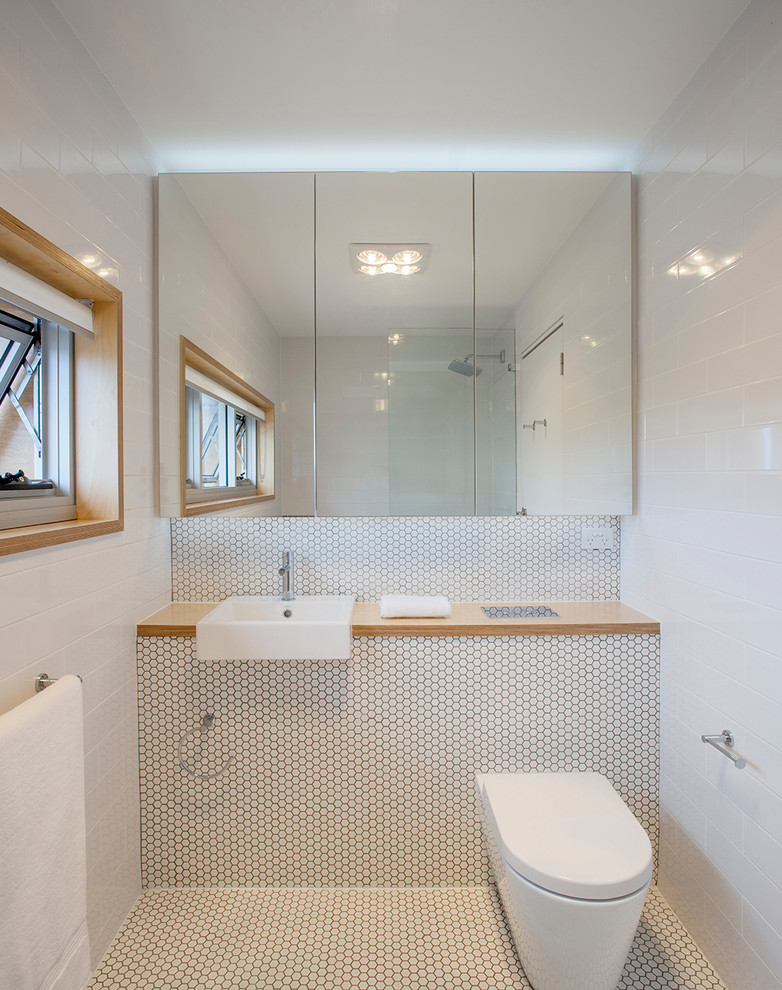 Immagine di una stanza da bagno con doccia contemporanea con WC sospeso, pareti bianche, pavimento con piastrelle a mosaico e pavimento bianco